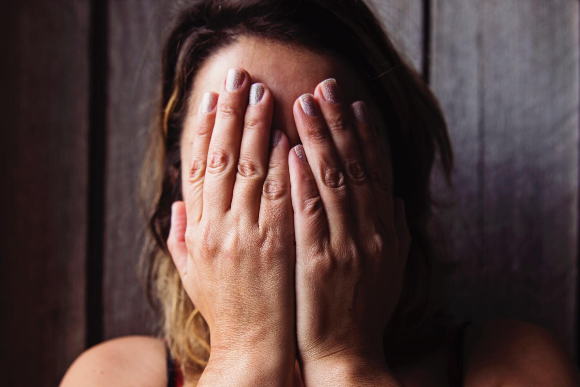 A woman covering her face with her hands