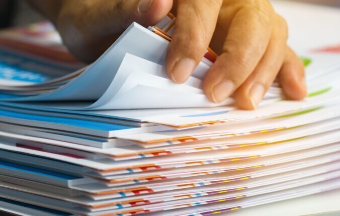 A hand rifling through pieces of paper