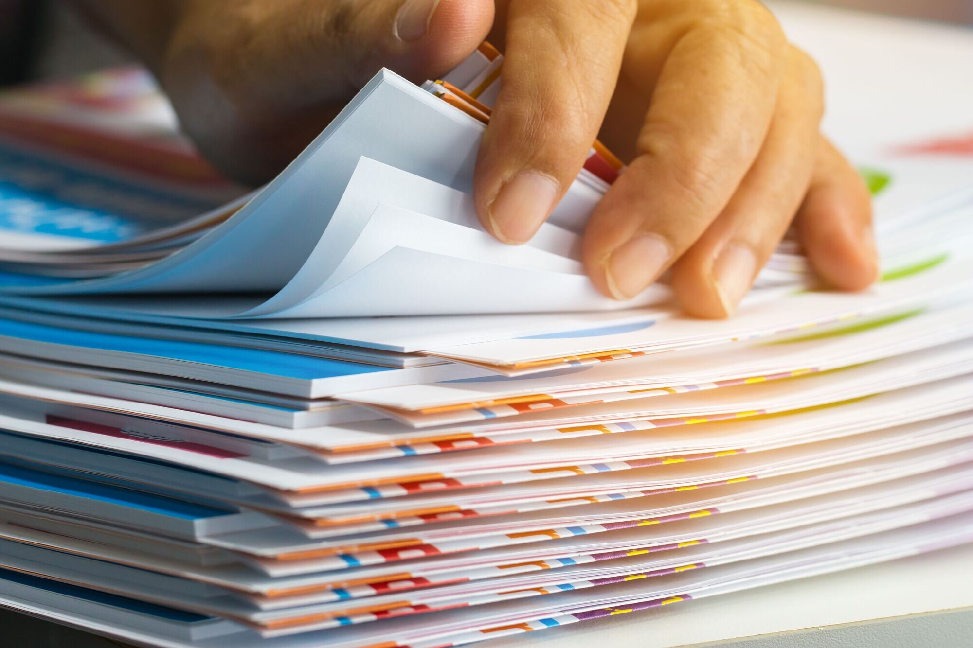 A hand rifling through pieces of paper