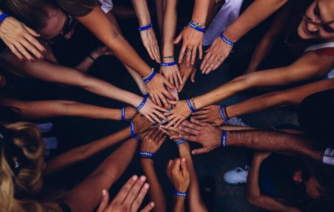 Hands of different skin tones joined together in the middle