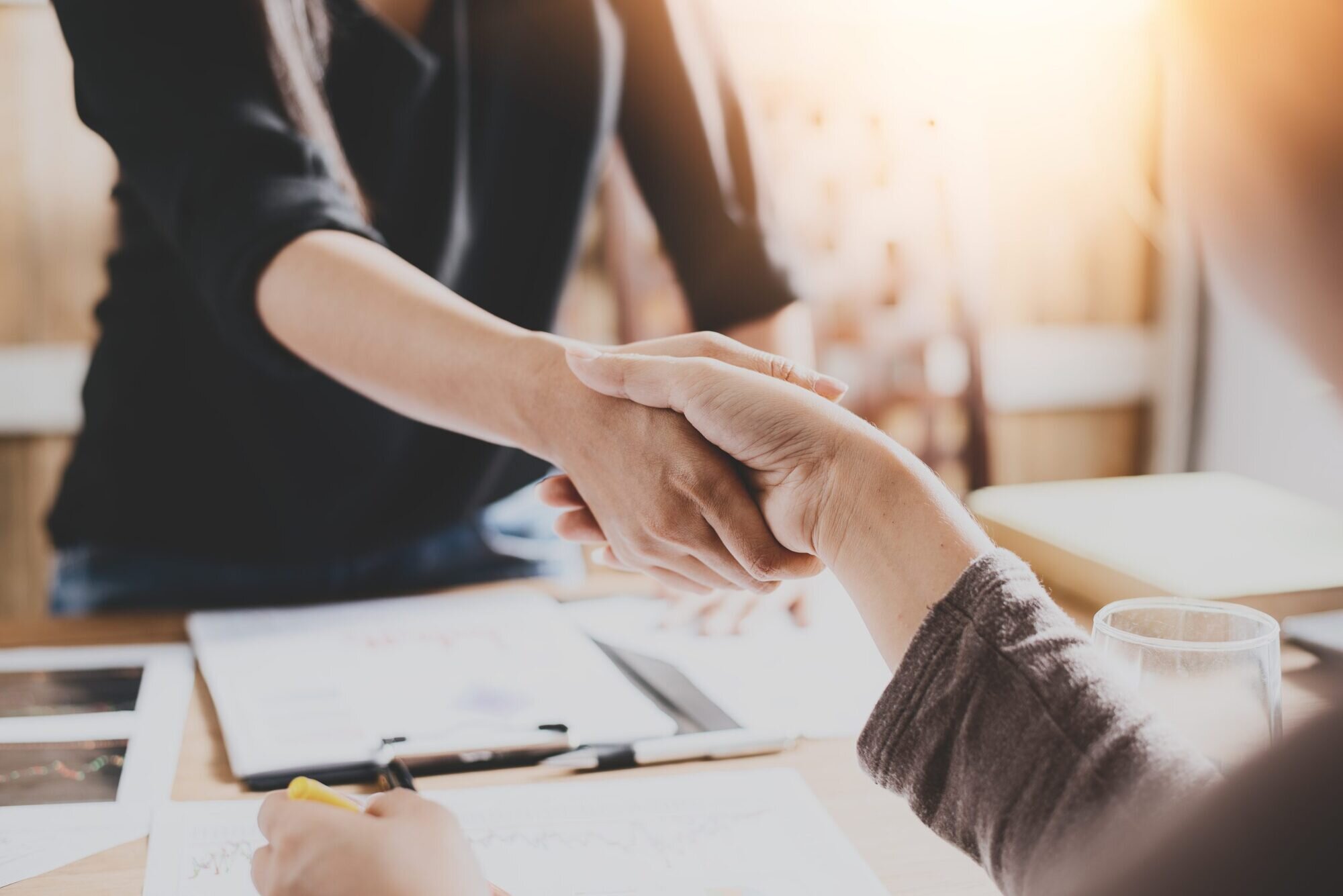 Two people shaking hands to close a deal