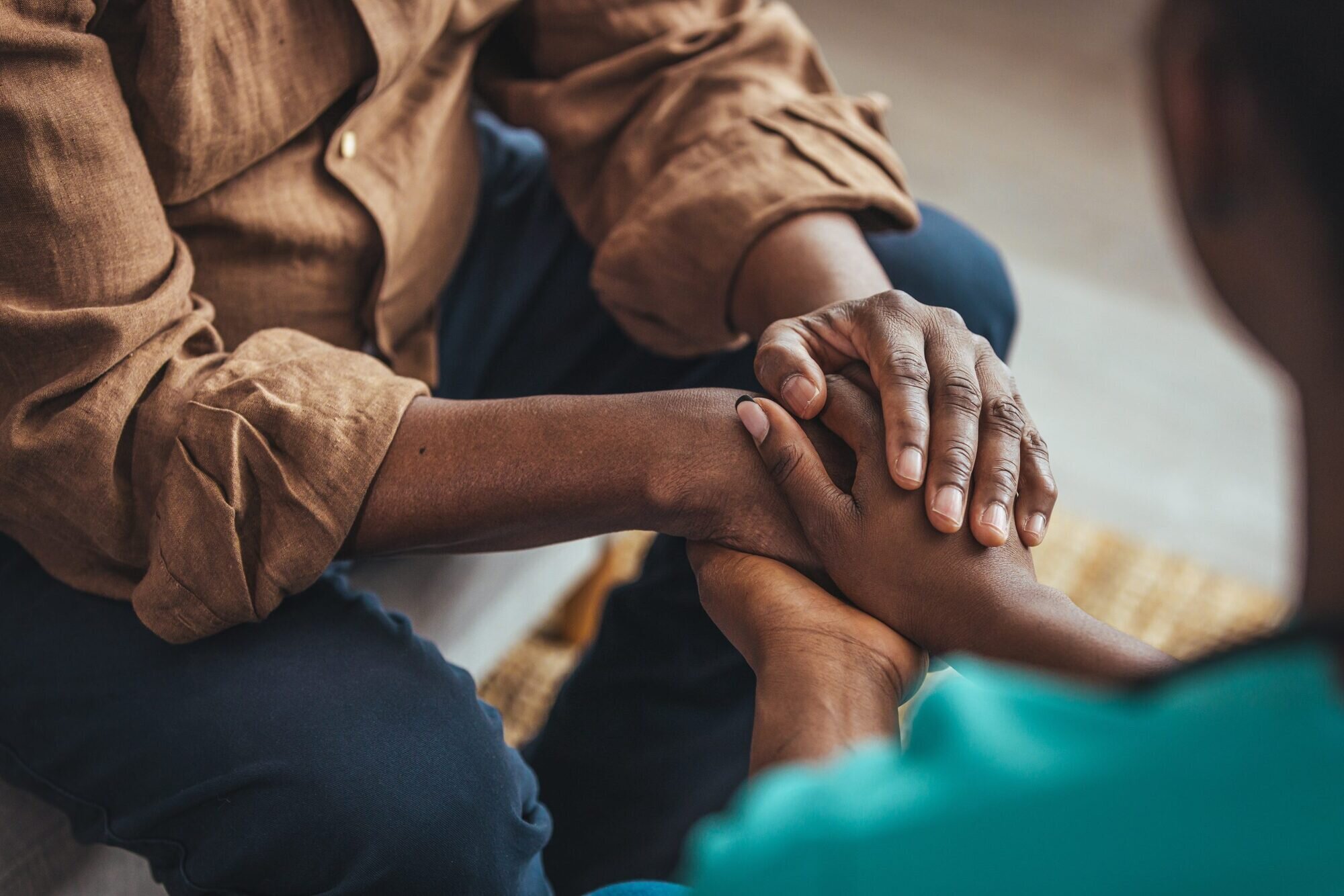 A person holding hands of another person in support