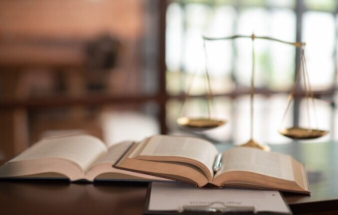 Law Books And Scales Of Justice On Desk