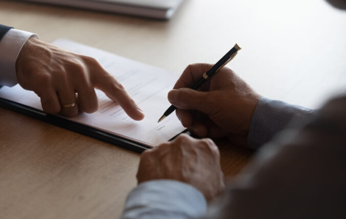 Hands Of Lawyer Pointing At Paper For Businessman Signing Contract
