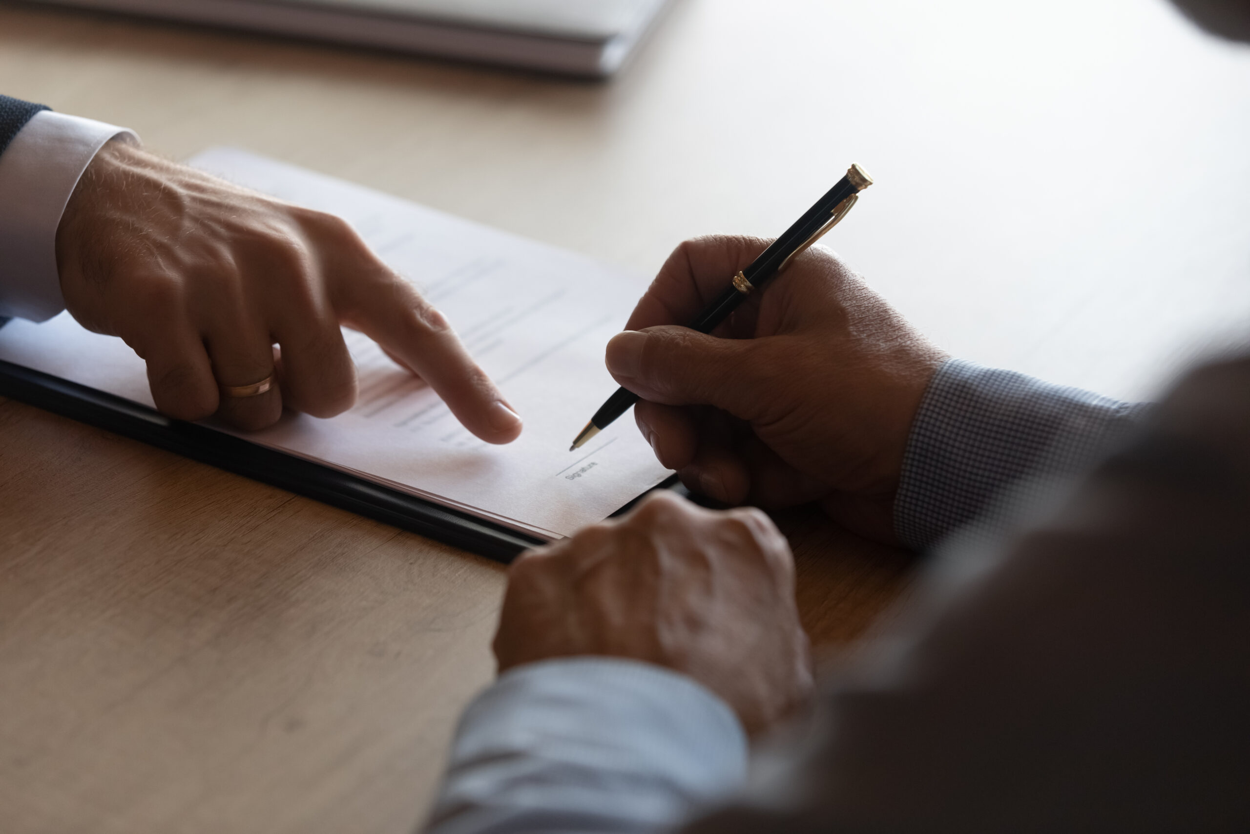 Hands Of Lawyer Pointing At Paper For Businessman Signing Contract