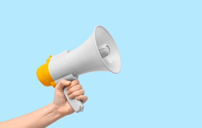 Female Hand With Megaphone On Blue Background
