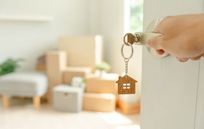 Keychain in the shape of a house hanging off a key in a lock