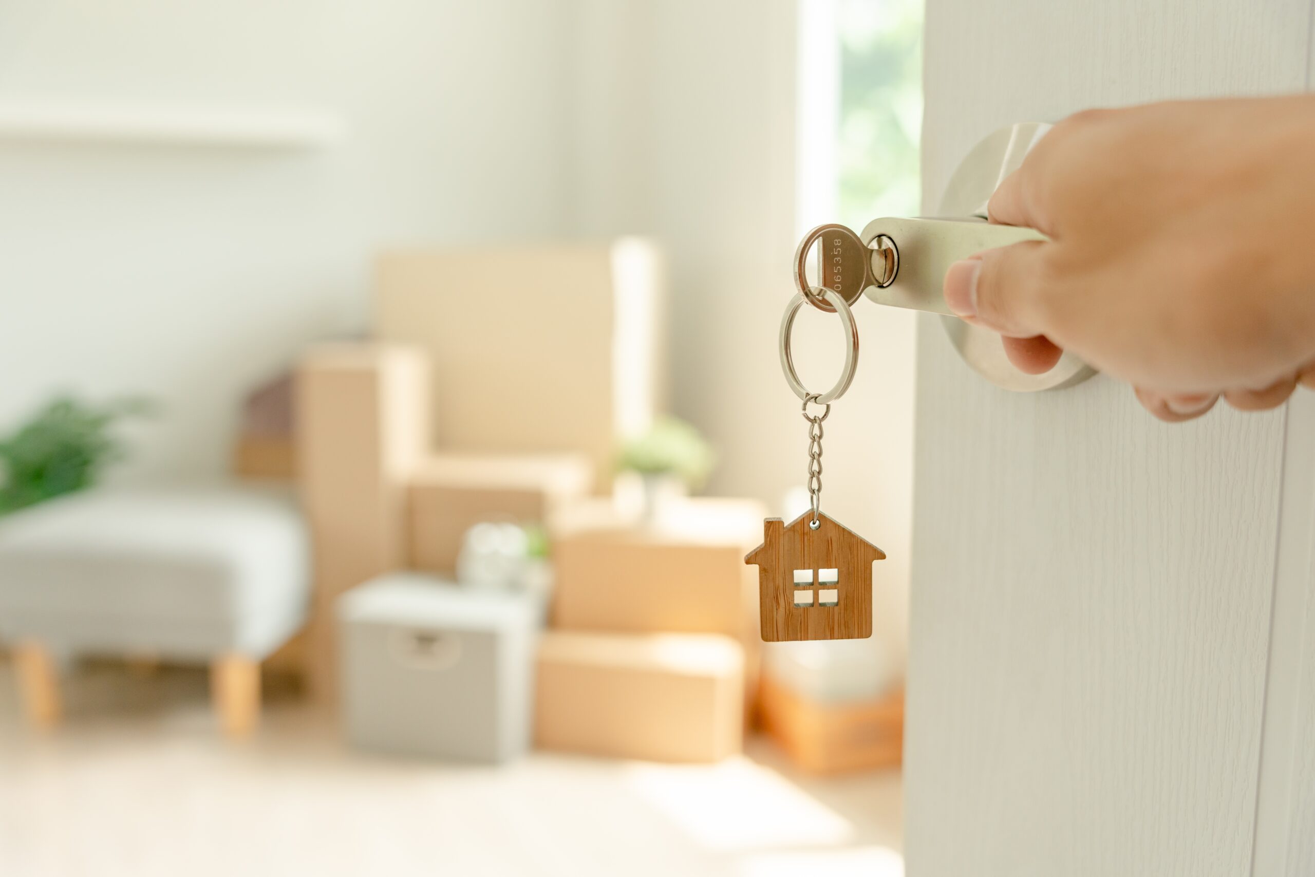 Keychain in the shape of a house hanging off a key in a lock