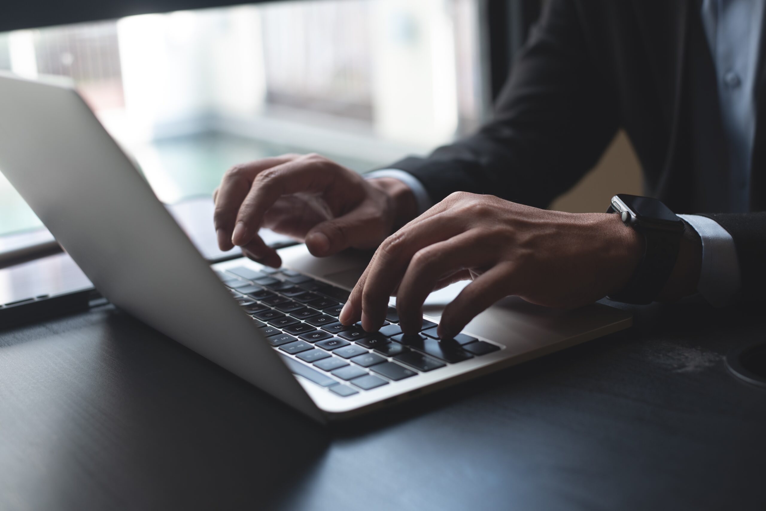 Close-up of hands typing on a laptop