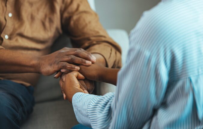 A person holding another person's hands in support