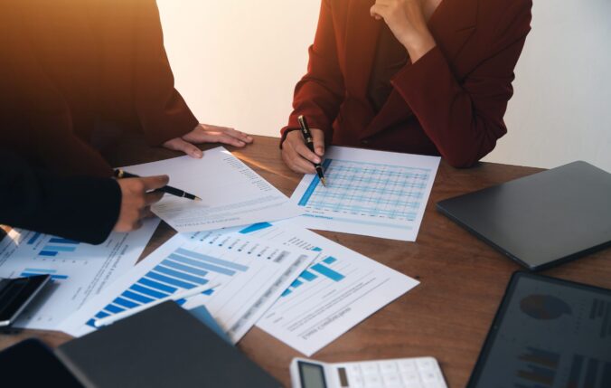 Two people checking reports and graphs